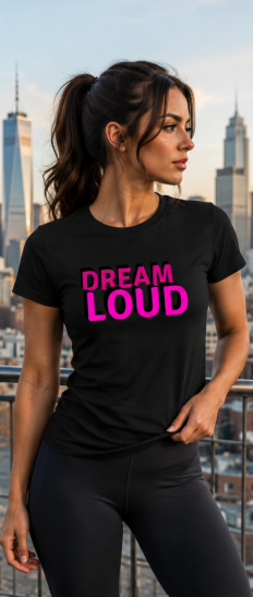 Woman wearing a black t-shirt with 'Dream Loud' text in pink, standing against a city skyline.
